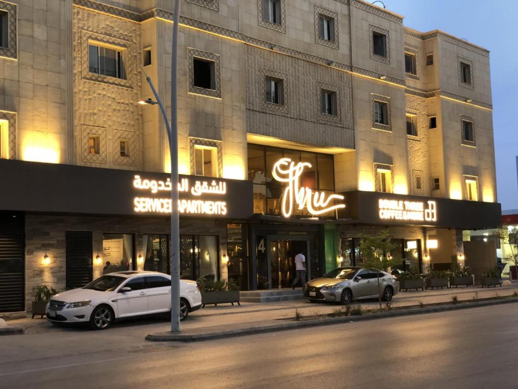 two cars parked in front of a building at شقق ثري ستار للشقق المخدومة in Riyadh