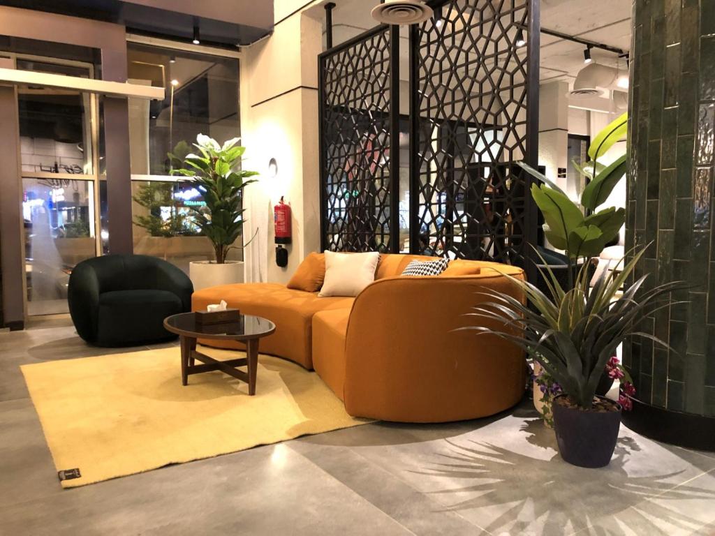 a living room with an orange couch and a table at شقق ثري ستار للشقق المخدومة 4 in Riyadh