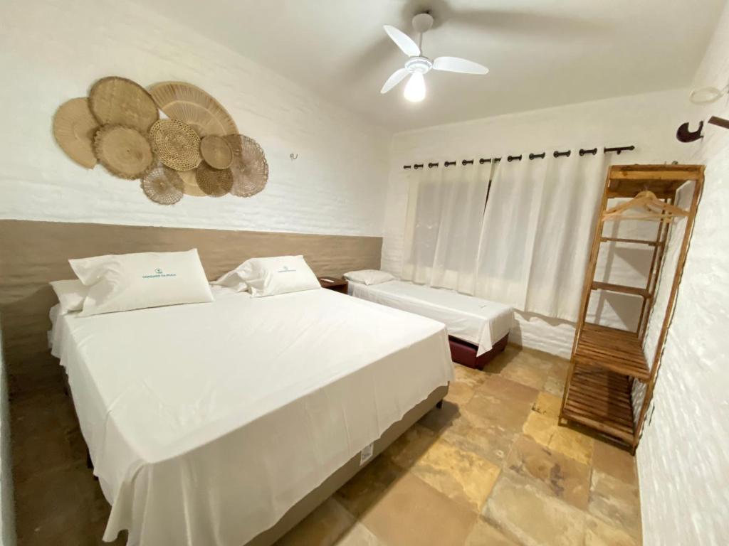 a bedroom with two beds and a ceiling fan at Condado da Praia ,casa em Flecheiras 7 a 10 suítes in Flecheiras