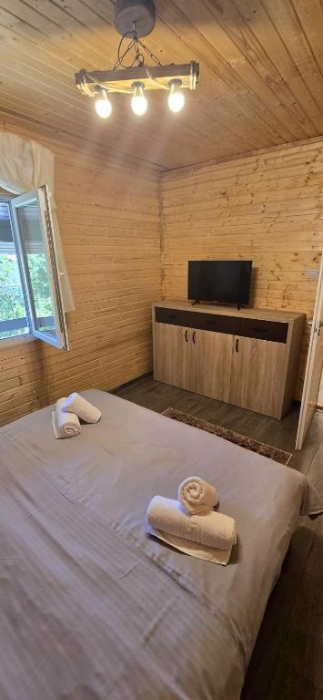 a bedroom with a large bed with towels on it at Cabanele din padure in Eşelniţa