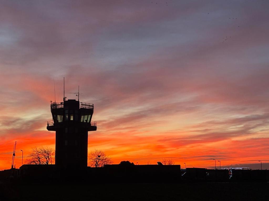 an airport control tower with a sunset in the background at The Tower in Boston