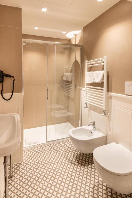 a bathroom with a shower and a toilet and a sink at Hotel Arlecchino in Venice