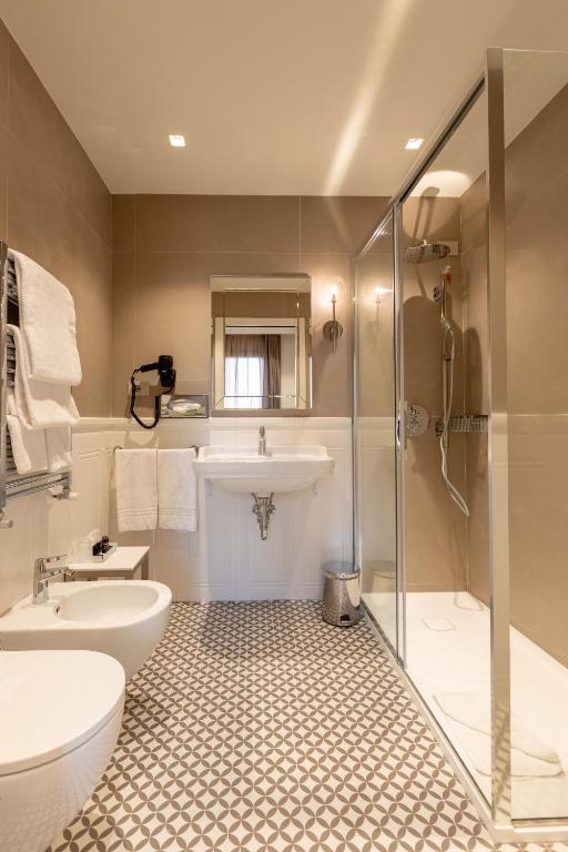 a bathroom with a sink and a toilet and a shower at Hotel Arlecchino in Venice