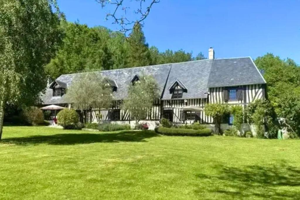 a large house with a large yard with green grass at Maison Le Clos Longlais - Welkeys in Grangues
