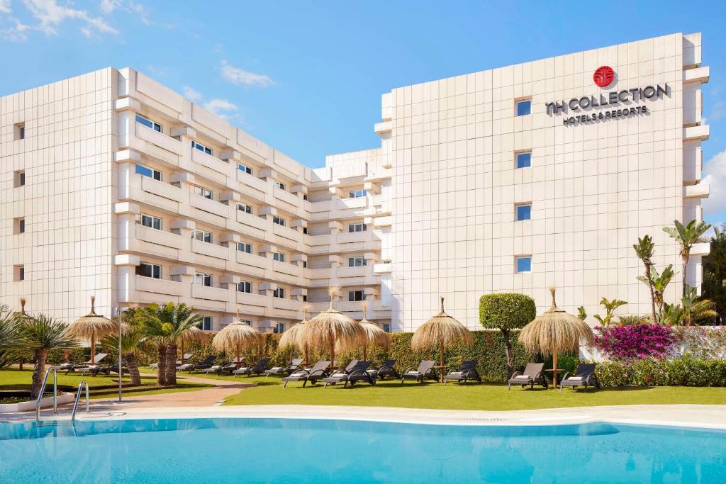 a hotel with a swimming pool in front of a building at NH Collection Marbella in Marbella
