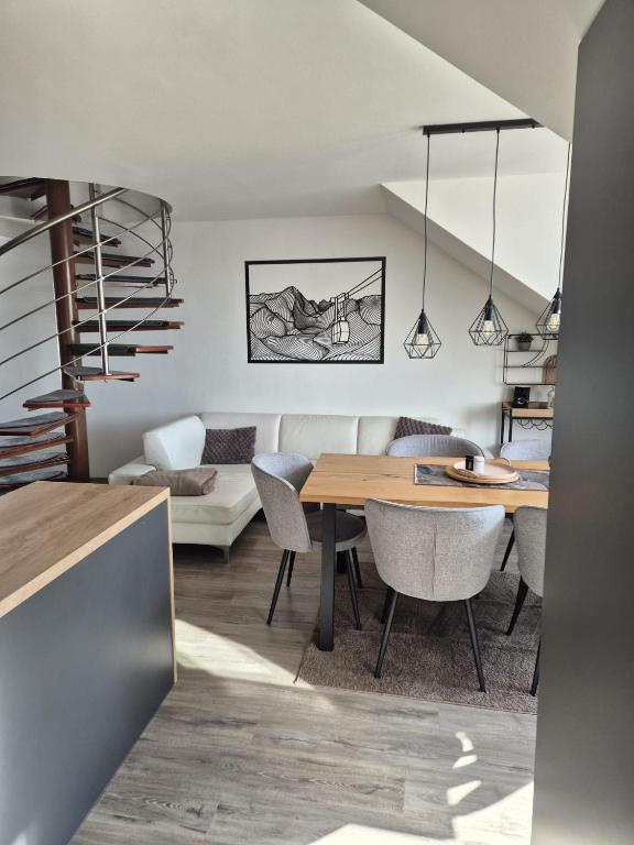 a living room with a dining room table and a couch at Apartman pod Smokovcom in Dolný Smokovec