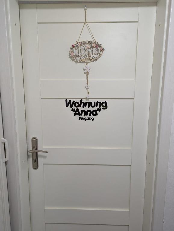 una porta bianca con un cartello sopra di Wohnung "Anna" a Stadtallendorf