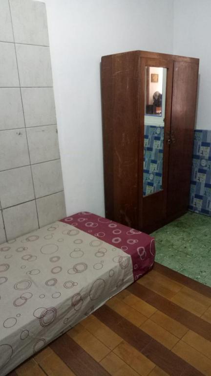 a small bed in a room with a bathroom at Kranggan Bethlehem Homestay in Yogyakarta