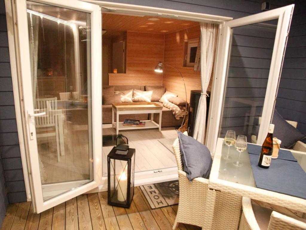 een afgeschermde veranda met een tafel en een bank bij Hausboot Poseidon 1 in Großenbrode