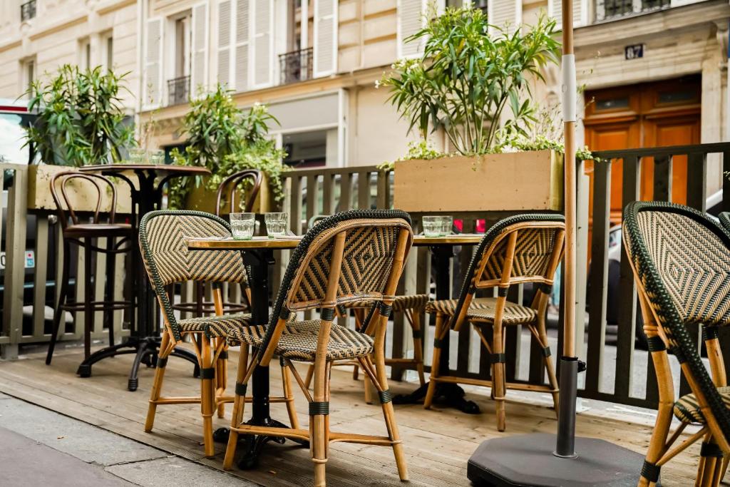 Un grupo de mesas y sillas en un patio. en Maison Eugenie, en París