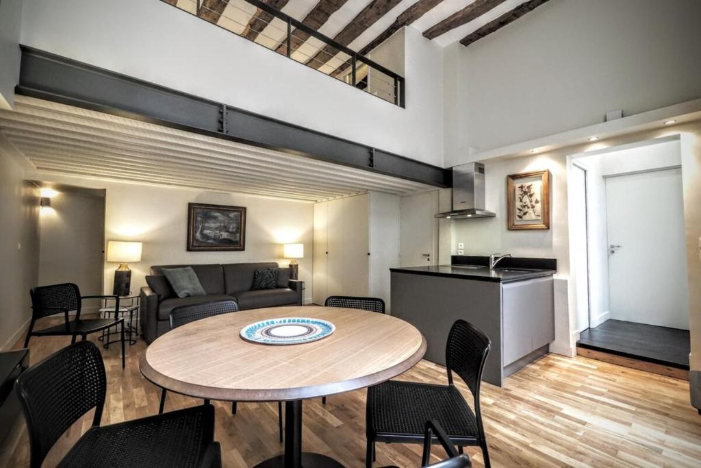 un salon avec une table et un canapé dans l'établissement Molière ChicSuites, à Paris