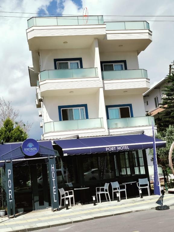 a hotel with a blue awning in front of a building at Port Hotel, Tasucu in Silifke