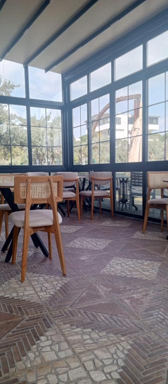 a room with tables and chairs and windows at Port Hotel, Tasucu in Silifke
