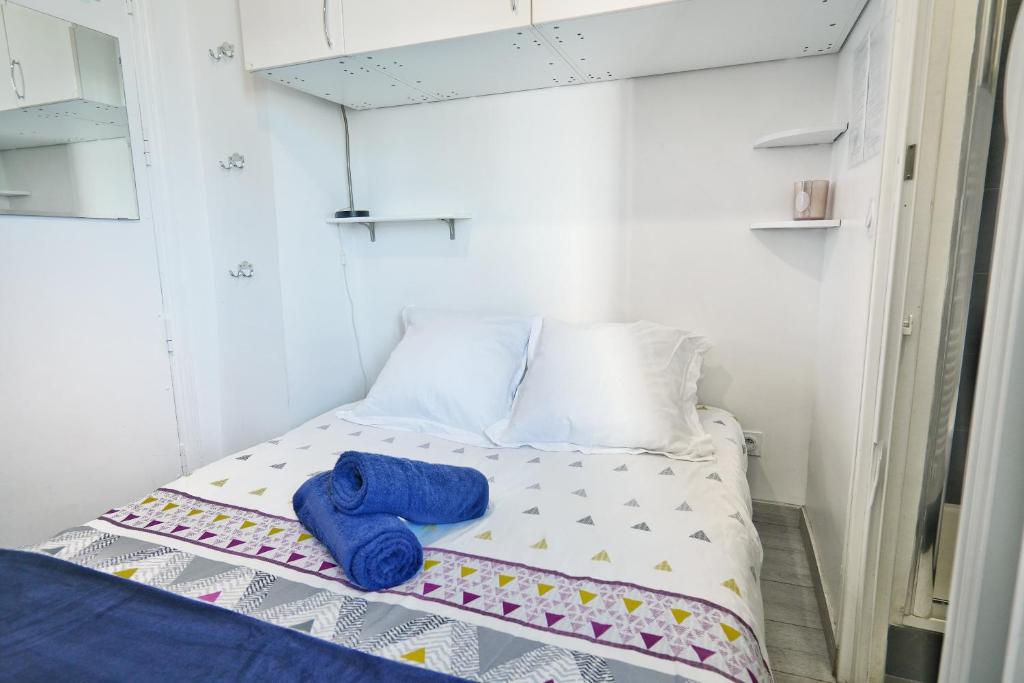 - un petit lit avec 2 serviettes bleues dans l'établissement Chess Flat - Paris Grands Boulevards, à Paris