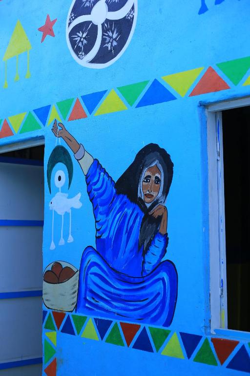 a painting of a woman on a wall at Mama Africa Camp in Luxor