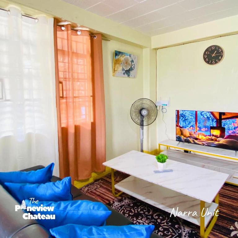 a living room with a couch and a table at 2-BR Narra Unit by The Pineview Chateau in Baguio
