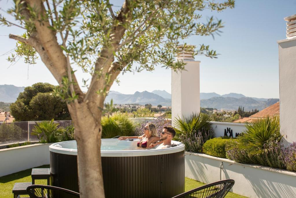 a couple in a hot tub on the roof of a house at Apartamentos Martalia Arenal in Ronda