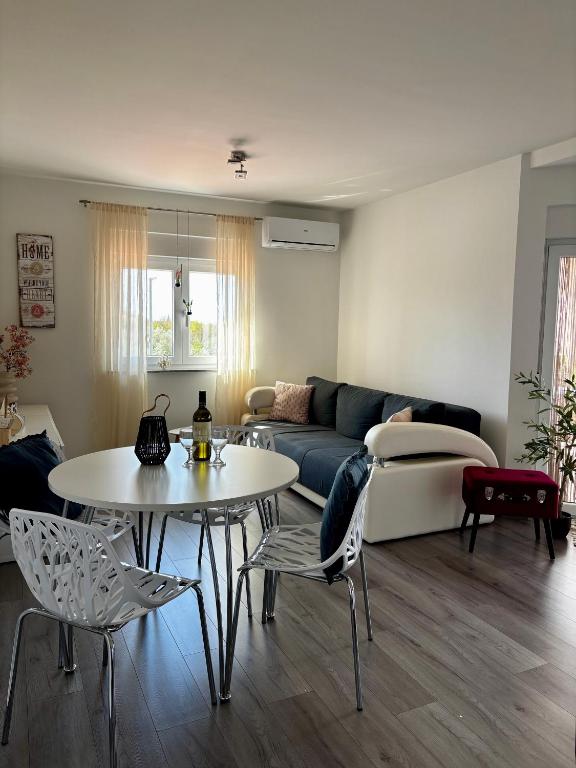 a living room with a couch and a table and chairs at Mila in Vodnjan