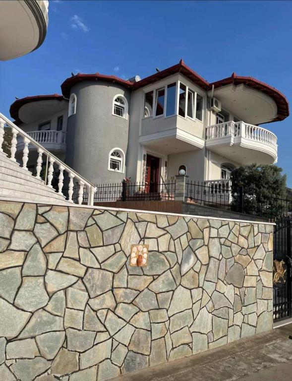a large house with a stone wall in front of it at SeaViewPeramou in Elevtheraí