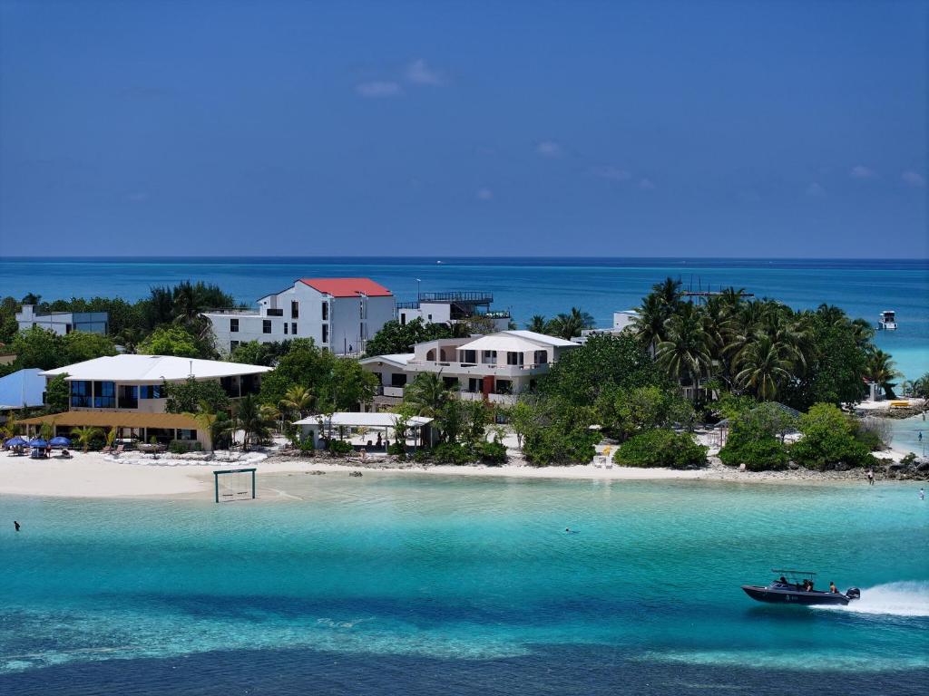 a boat in the water next to a beach at Summer Luna in Dhiffushi