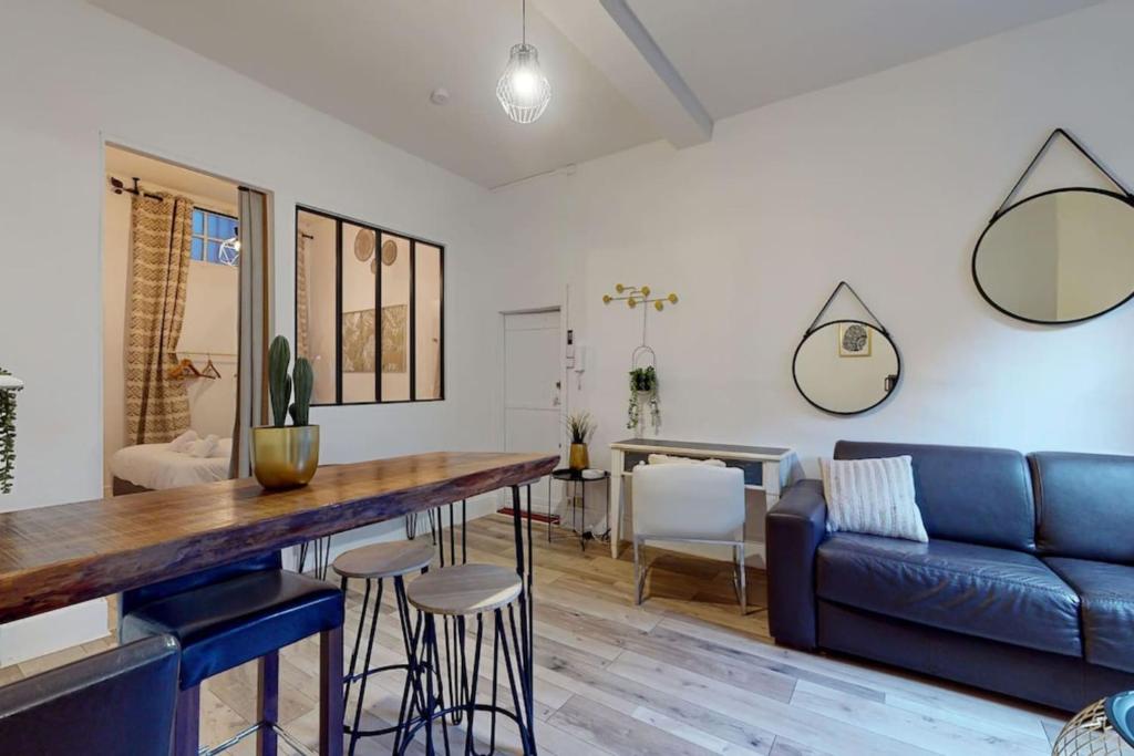 un salon avec un canapé bleu et une table dans l'établissement Parga 2 Terrasse Clim - Capitole - Bord Garonne, à Toulouse