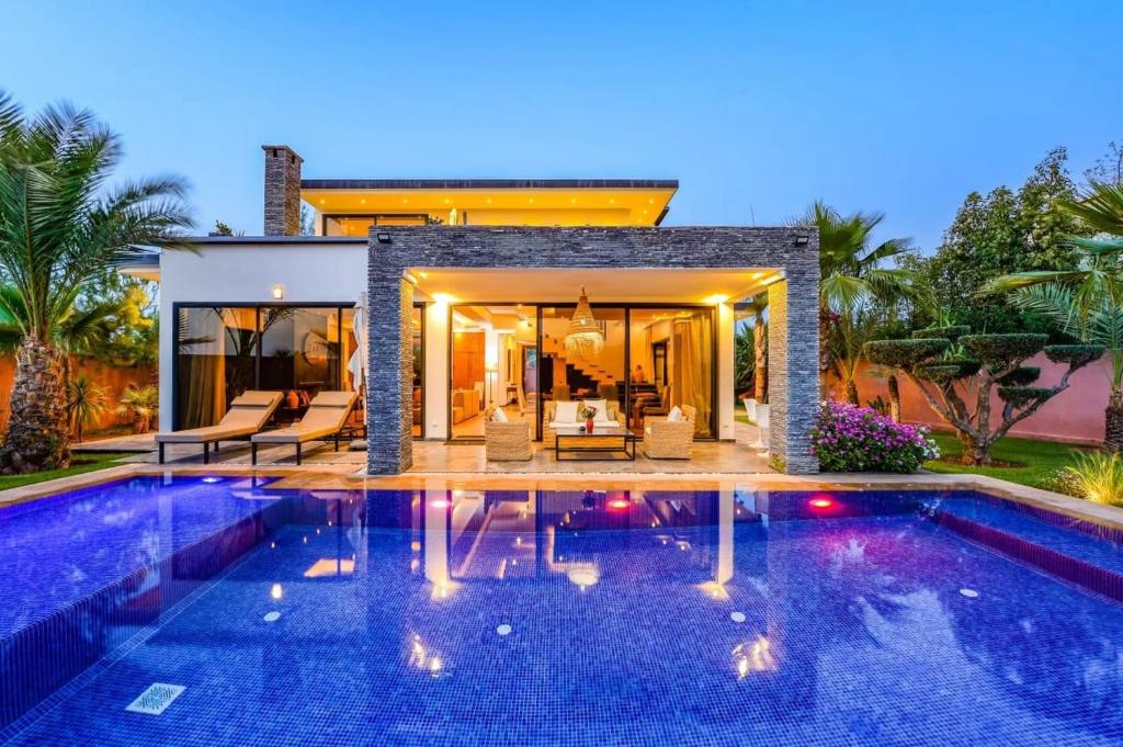 a swimming pool in front of a house at Villa Alia - Piscine privée 3 Ch Navette Aéroport Gratuit in Marrakech