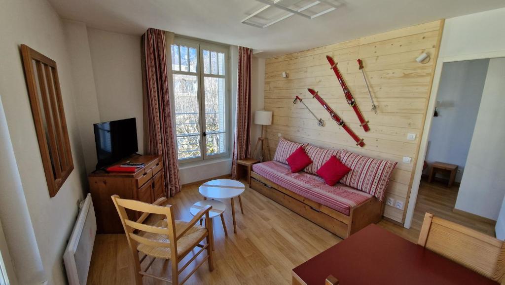 un salon avec un canapé et une télévision dans l'établissement T3 centre-ville Bagnères-de-Luchon, à Luchon