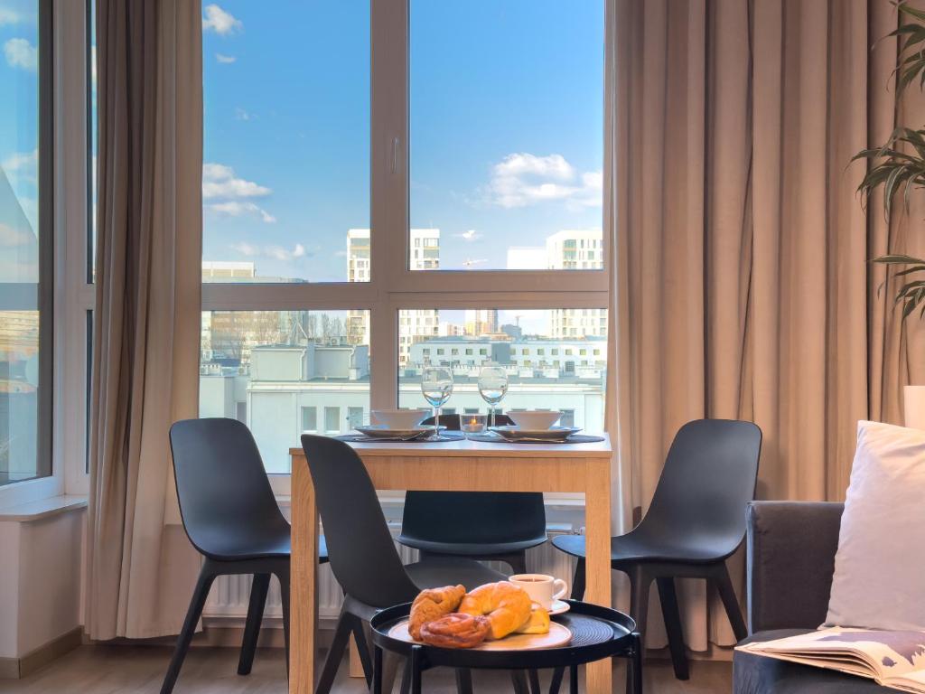 a dining room with a table and chairs and a large window at URBAN APARTMENTS PREMIUM, Opolska 10 No 91, Free Garage, Self Check-in in Katowice