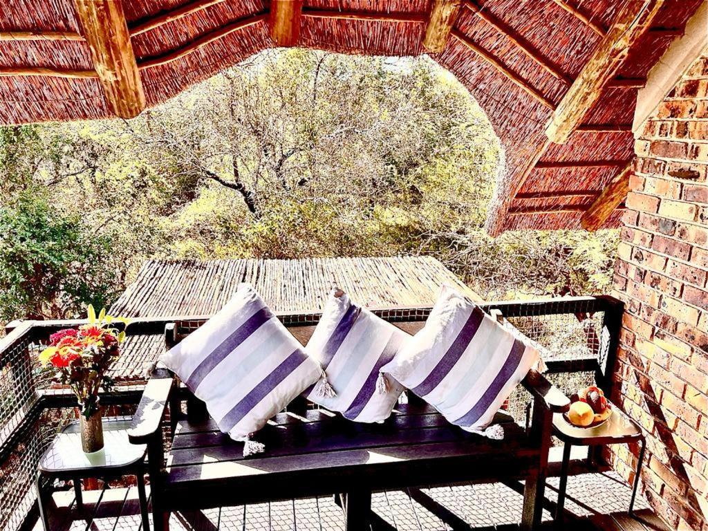 a picnic table with pillows on a patio at Ingwenya View in Marloth Park