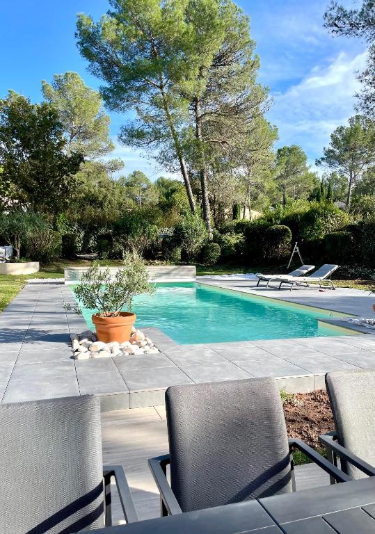 une piscine avec des chaises dans une cour dans l'établissement Villa St Endréol Golf & Spa I Piscine Chauffée I, à La Motte