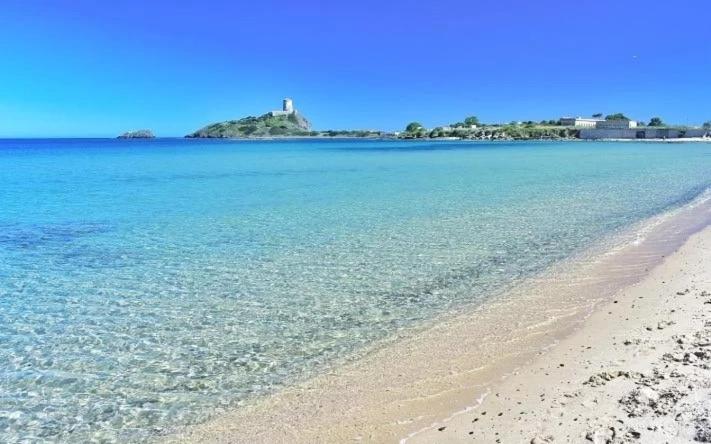 a beach with the ocean and a lighthouse in the background at Casa House Villa Chiara in Pula