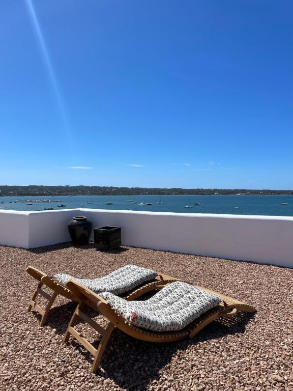 a chaise lounge on a beach next to the water at Formentera Especial in La Savina