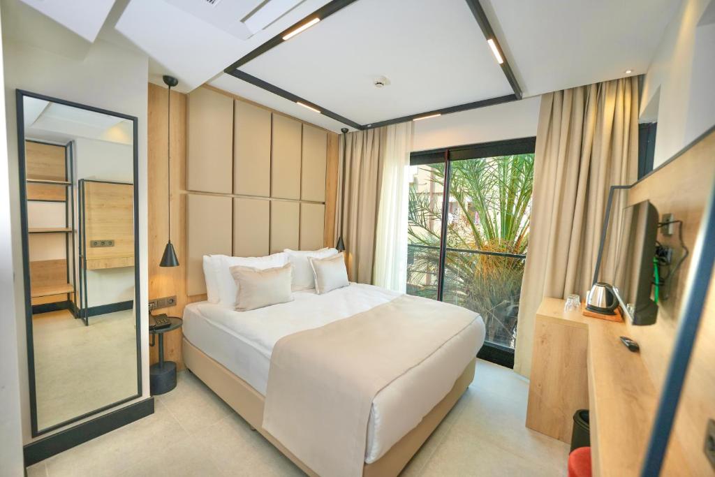 a bedroom with a white bed and a large window at Aylin Otel in Marmaris