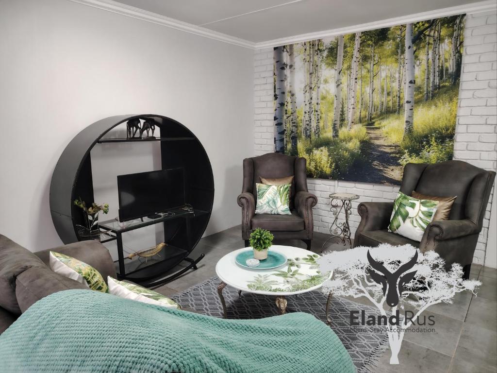 a living room with a couch and chairs and a tv at Eland Rus Micro Stay Self Catering in Kathu