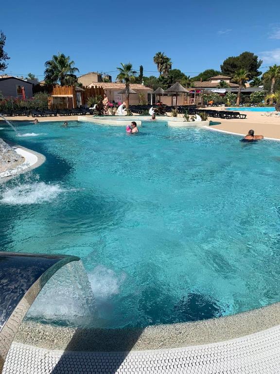 - une piscine d'eau bleue dans un complexe dans l'établissement Camping Siblu les Sables du Midi, à Valras-Plage