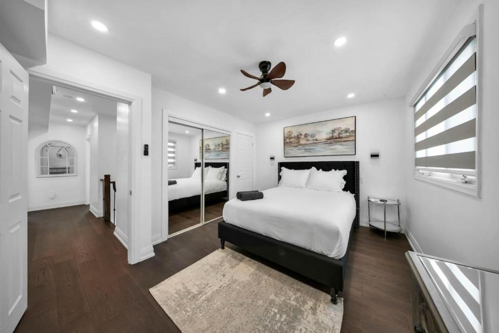 トロントにあるHidden 3BR Gem with Workspace, Fast wifi and Parkingの白いベッドルーム(ベッド1台、天井ファン付)