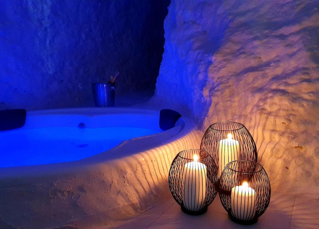 three candles sitting next to a bath tub with lights at casa cueva a 15 minutos del centro de Valencia in Paterna