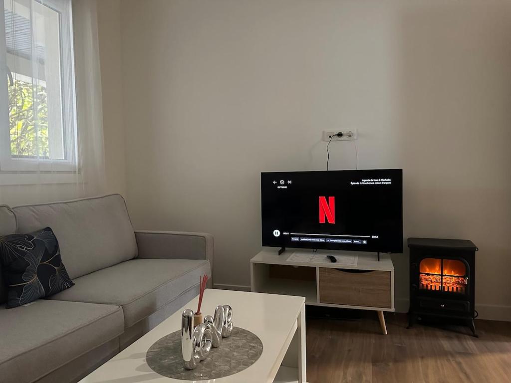 Il comprend un salon doté d'un canapé, d'une télévision et d'une cheminée. dans l'établissement DYLAN Apartment, near Paris, à Montreuil