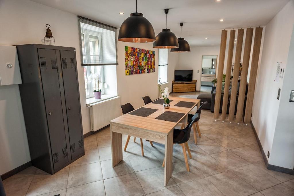 une cuisine et une salle à manger avec une table et des chaises en bois dans l'établissement La Brocante, à Granges-Aumontzey