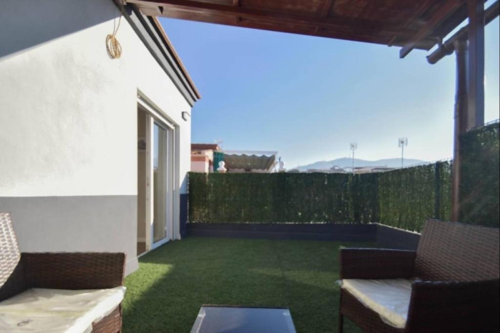 een patio met groen gras en een wit gebouw bij Home4u San Ambrosio in Granada