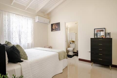 Old HarbourBellaRose at Colbeck ,Gated with Pool, Stylishly modern的一间卧室配有一张床和一个梳妆台,还设有一间浴室