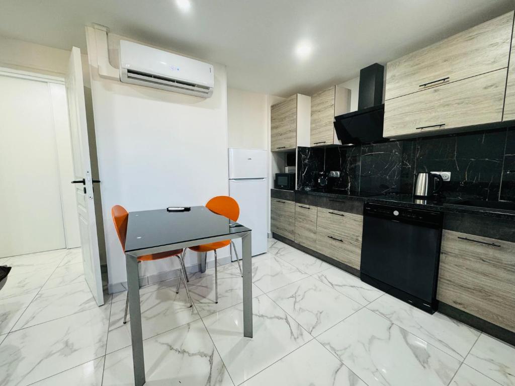 une cuisine avec une table et des chaises dans une pièce dans l'établissement Appartement 300m de la mer, à Valras-Plage