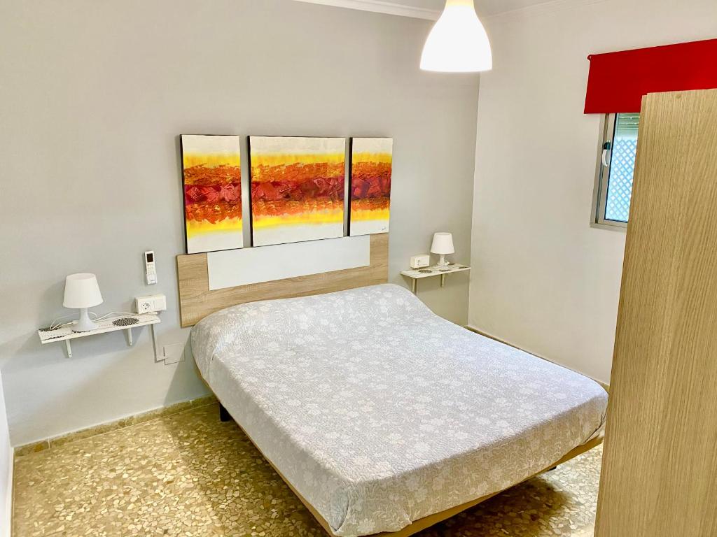 une chambre avec un lit et trois fenêtres dans l'établissement Apartamentos turísticos en Jerez de la frontera, à Jerez de la Frontera