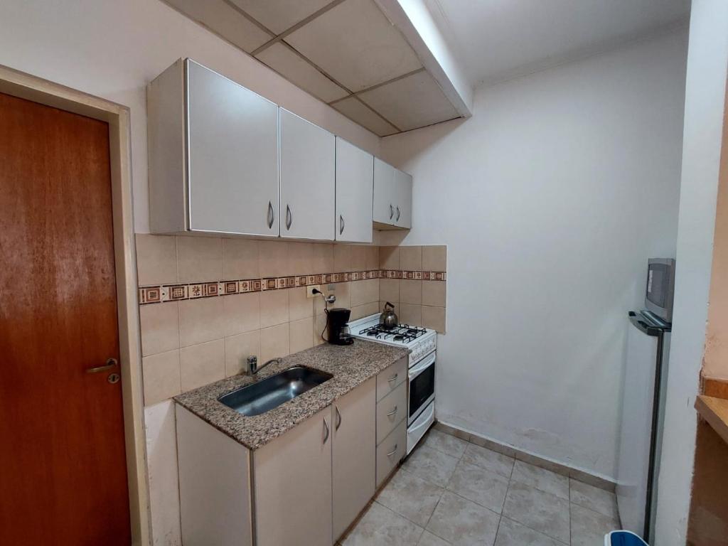 a small kitchen with a sink and a stove at Dto funcional MT in Bahía Blanca