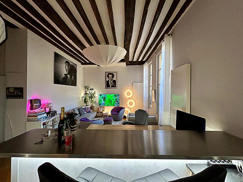 un salon avec un plafond à caissons et une table dans l'établissement Superbe et inoubliable Appart Le Marais Paris, à Paris