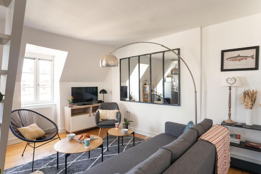 - un salon avec un canapé, des chaises et un miroir dans l'établissement Le Tourmentin - Vue Port, à Saint-Malo