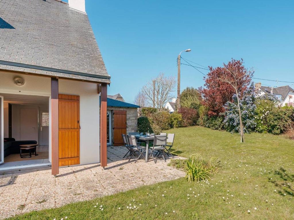 un patio avec une table et des chaises dans une cour dans l'établissement Maison Carnac 3 pièces, plage à 200m, jardin clos, parking, idéal famille - FR-1-477-85, à Carnac