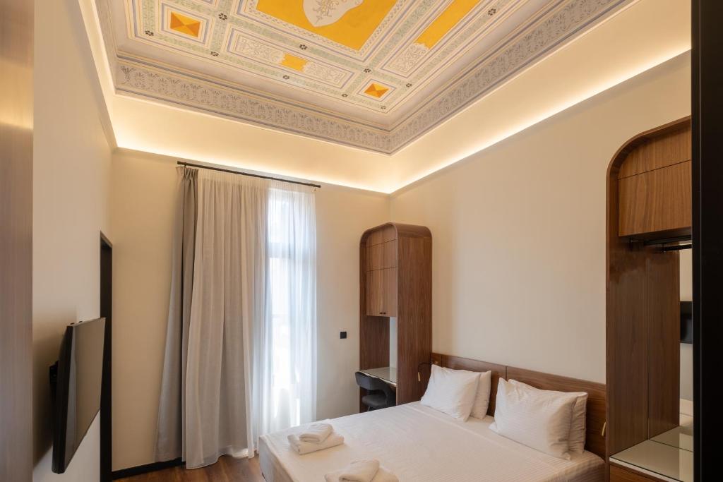 een slaapkamer met een bed en een schuin plafond bij Bouquet Luxury Rooms in Chania