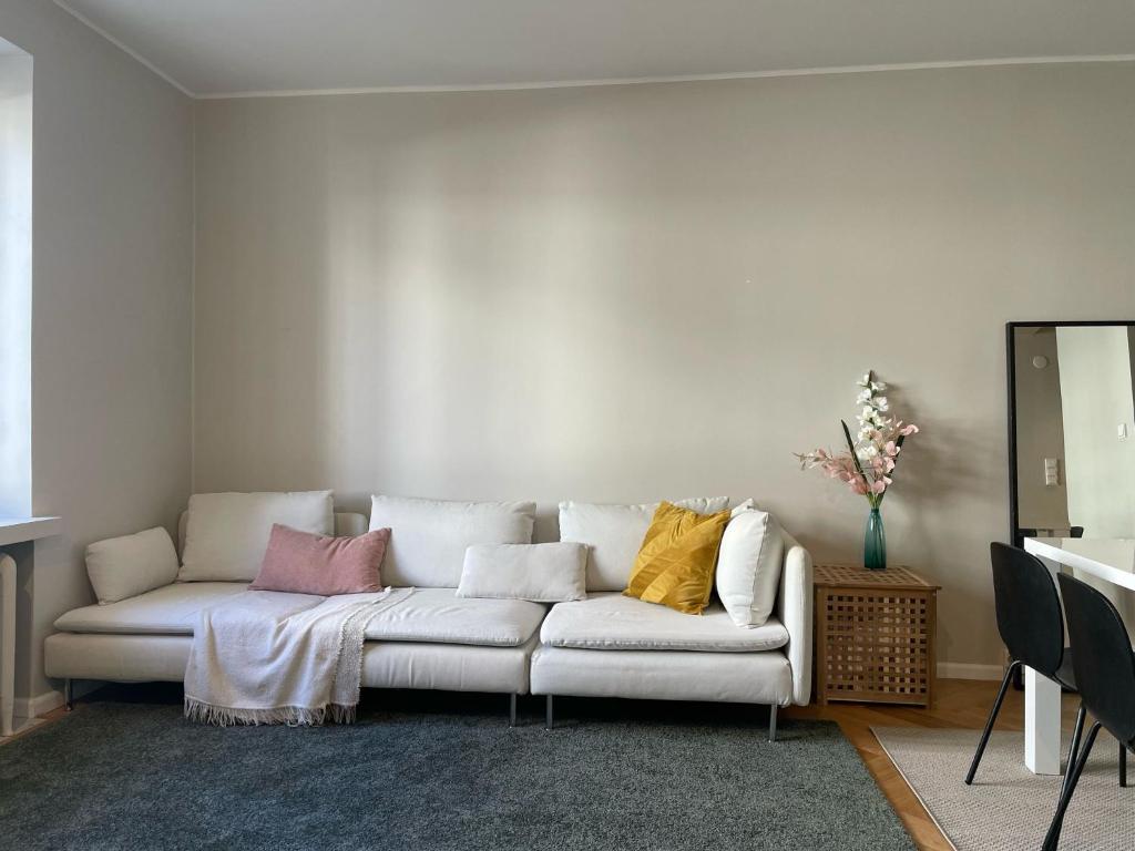 un soggiorno con un divano bianco con cuscini colorati di Luxury 2BDR Apartment in Center with Free Parking a Helsinki