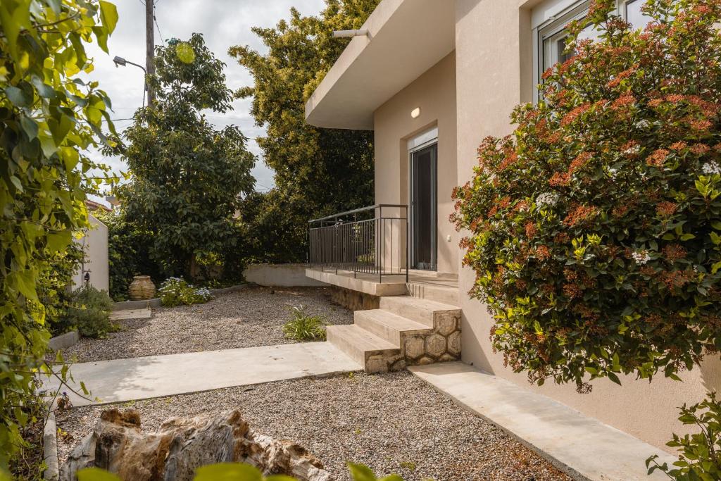 a house with stairs and flowers in front of it at LazyDays in Analipsi in Análipsis